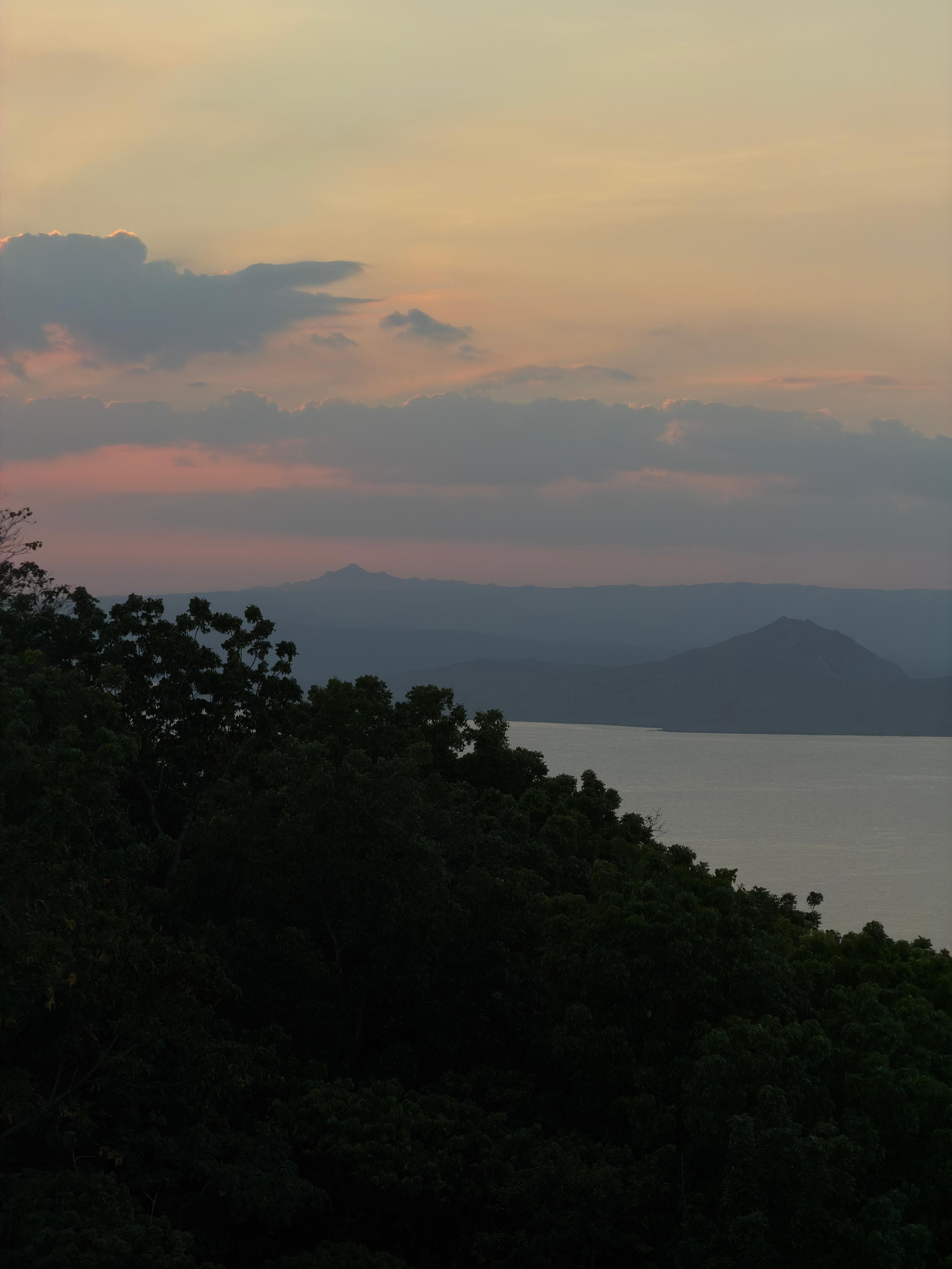 Taal at twilight, the volcano silhouetted against a pink sky